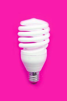 Energy saving light bulb on pink background. Copy space