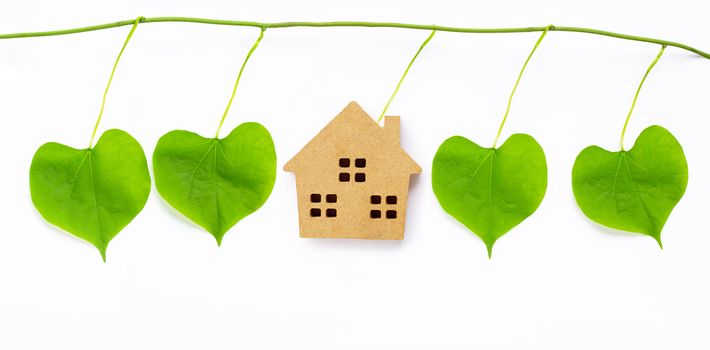 Little wooden house with green leaves heart shaped on white background.