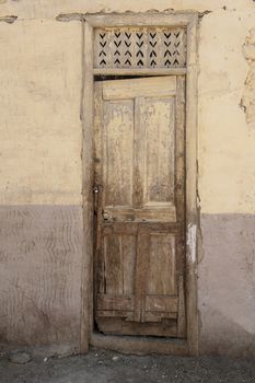 Old rustic door in wall of abandoned traditional egyptian house