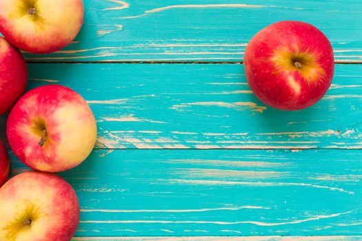 Group of red apple on blue wooden background.