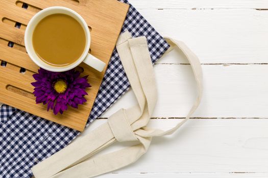 Relaxing break with coffee cup and white wooden background.