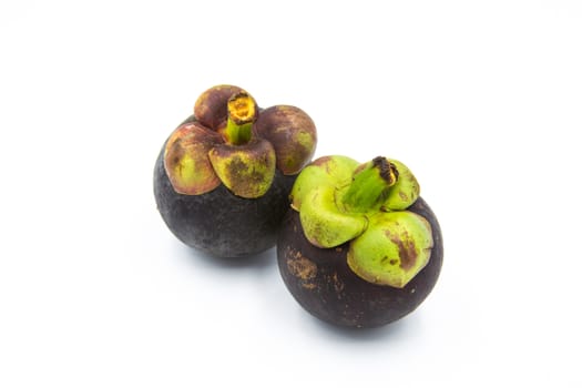 Two mangosteen placed on the white ground.