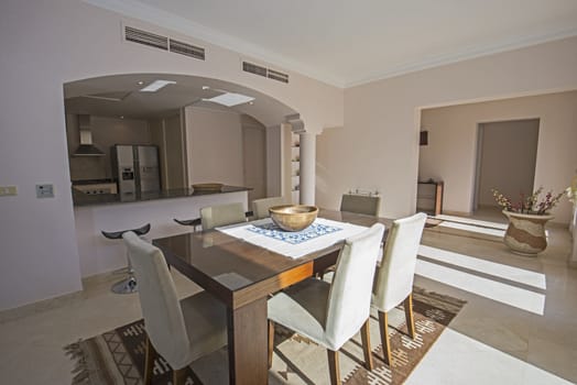 Kitchen and dining area in luxury apartment show home showing interior design decor furnishing with dining table