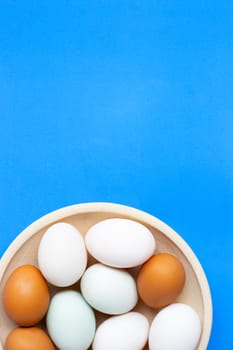 Eggs on blue background. Top view with copy space