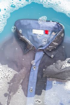 Shirt soak in powder detergent water dissolution, washing cloth. Laundry concept