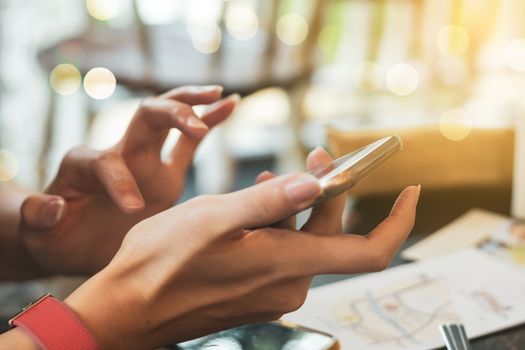 People hand using smartphone with blur cafe shop background. Business, financial, trade stock maket and social network concept.