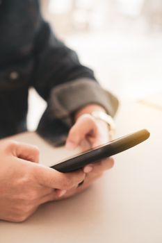 Womanhand using smartphone to do work business, social network, communication in public cafe work space area.