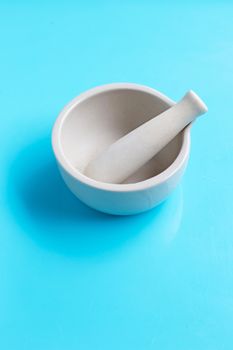 Mortar and pestle on blue background. Copy space