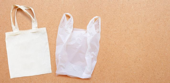 White fabric bag with white plastic bag on plywood background.  Copy space