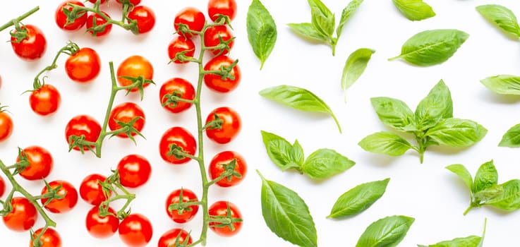 Fresh  cherry tomatoes with basil leaves on white background. Top view