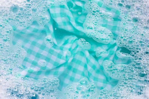 Green white tablecloth  soak in powder detergent water dissolution, washing cloth. Laundry concept