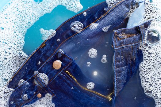 Jeans soak in powder detergent water dissolution, washing  cloth. Laundry concept
