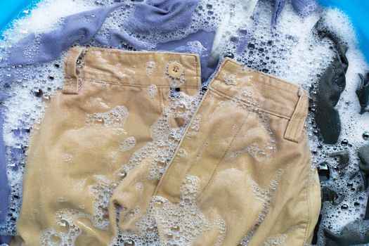 Trousers soak in powder detergent water dissolution, washing cloth. Laundry concept