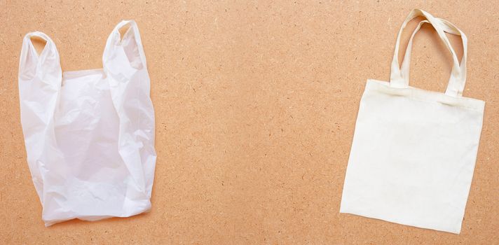 White fabric bag with white plastic bag on plywood background.  Copy space