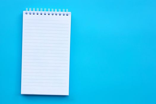 Blank notepad on  blue background. Copy space