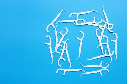 White toothpicks on blue background. Copy space