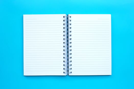 Open diary on blue background. Top view
