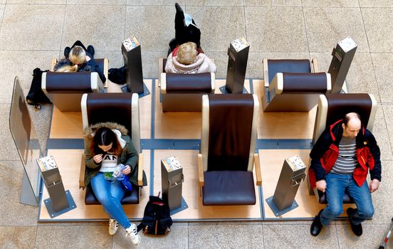 Braunschweig, Lower Saxony, Germany, January 27,2018: Customers in a shopping mall use the massage chairs as a waiting area