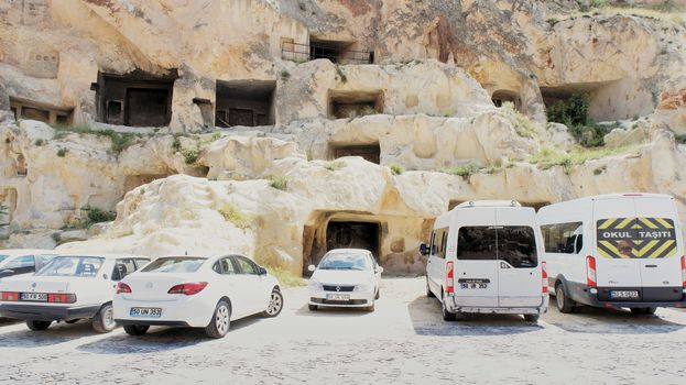 Uegruep, Anatolia, Turkey, July 2nd 2015: Parking in Cappadocia with old former rock flats in the background