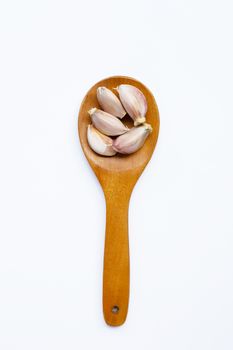 Garlic on wooden spoon on white background. 