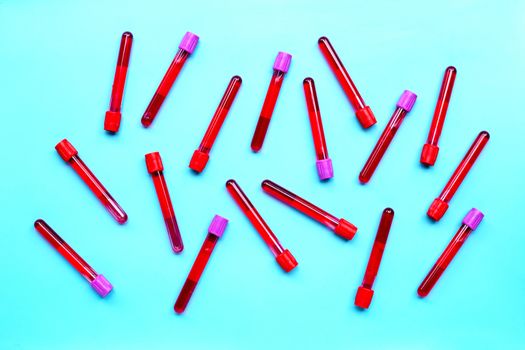 Blood in test tubes on blue background. Top view