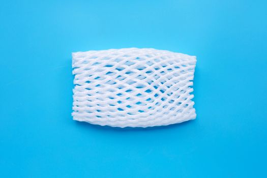 Fruit foam net for protection on blue background. Top view