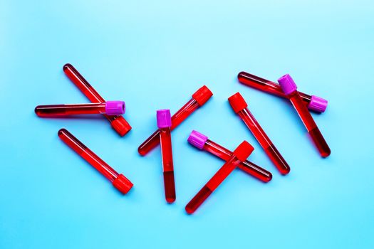 Blood in test tubes on blue background. Top view