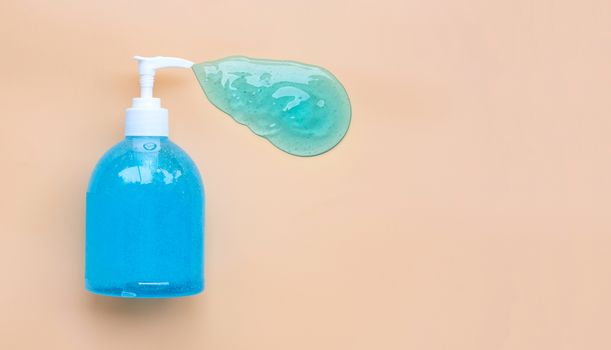 Alcohol hand sanitizer gel in pump bottle on old rose color background. Copy space