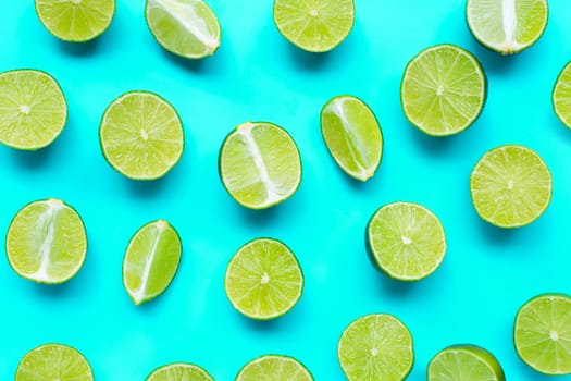 Fresh limes on blue background. top view