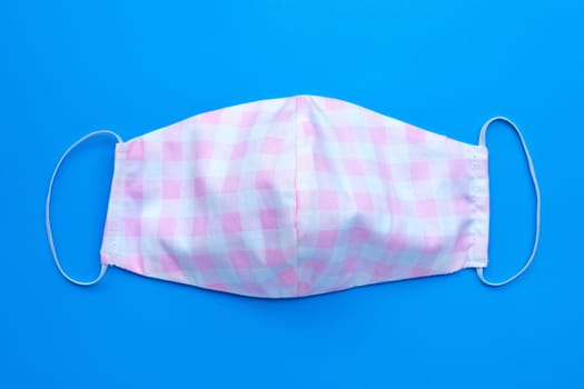 Handmade cloth masks on blue background. Top view