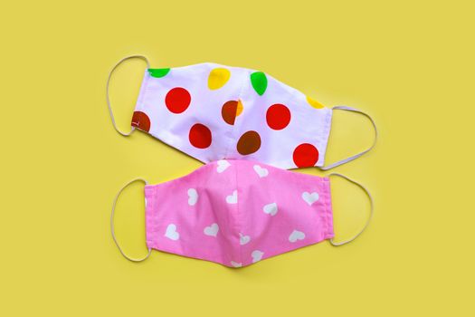 Handmade colorful cloth masks on yellow background. 