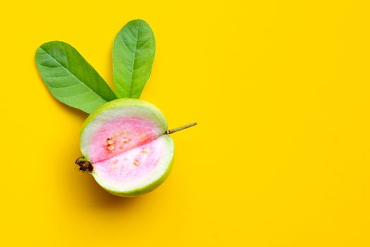 Top view of fresh ripe guava with leaf on yellow background. Copy space