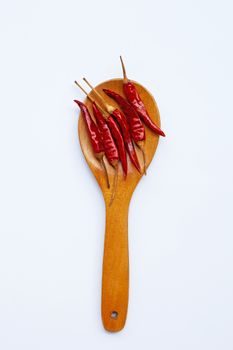 Dry red hot chili peppers on wooden spoon on white background. 