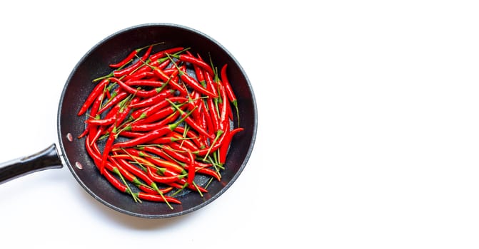 Hot chili peppers in a pan on white background. Copy space