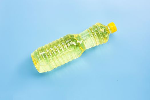 Oil in plastic bottle on blue background. Copy space