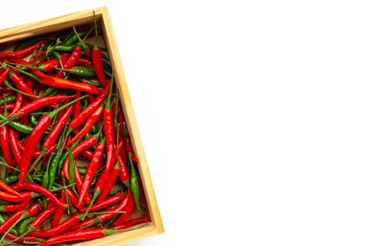 Hot chili peppers in wooden box on white background. Copy space