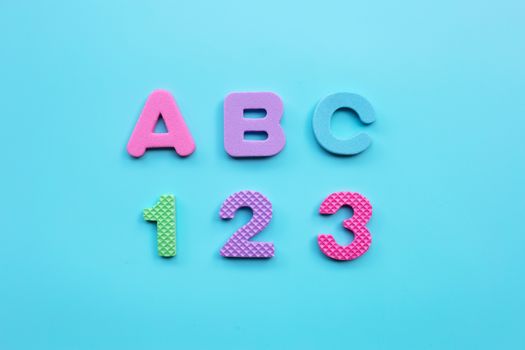 English alphabet and numerals on blue background. Education concept, Copy space