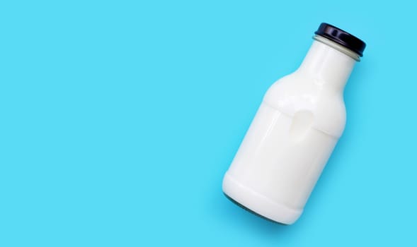 Milk bottle on blue background. Copy space