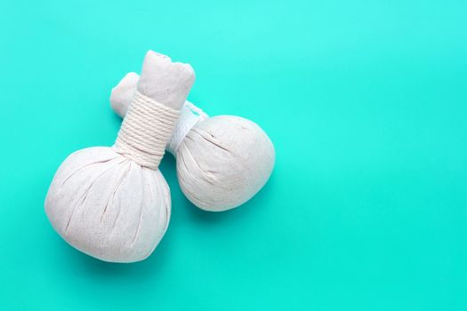 Herbal compress balls for Thai massage and spa treatment  on green background.  Copy space