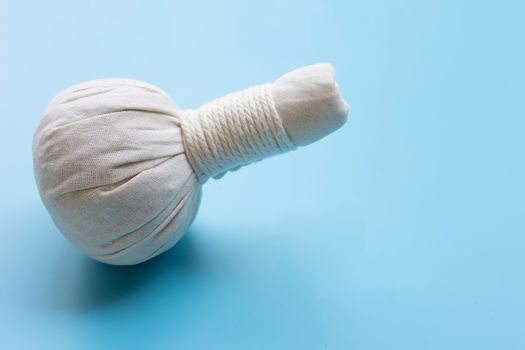 Herbal compress ball for Thai massage and spa treatment  on blue background.  Copy space