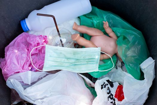 Dirty used surgical mask in a garbage bin.