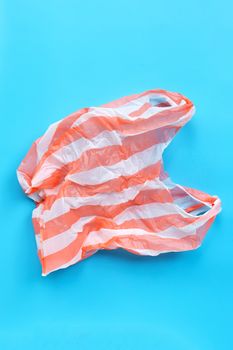 Colorful plastic bag on blue background. Environment pollution concept. Top view