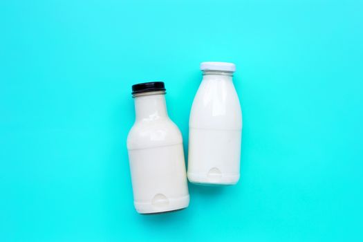 Milk bottle on blue green background. Copy space