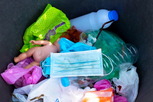 Dirty used surgical mask in a garbage bin.
