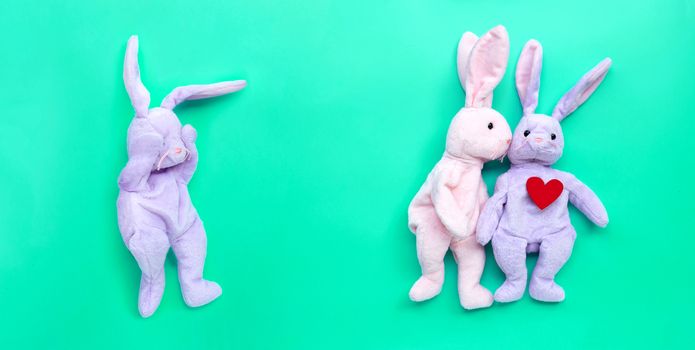 Broken heart rabbit toy with rabbit couple in love on green background. Copy space