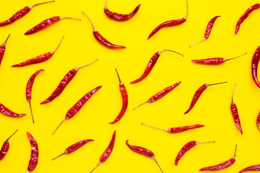 Dry red hot chili peppers on yellow background. Top view