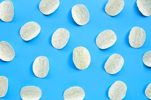 Potato chips on blue background. Top view