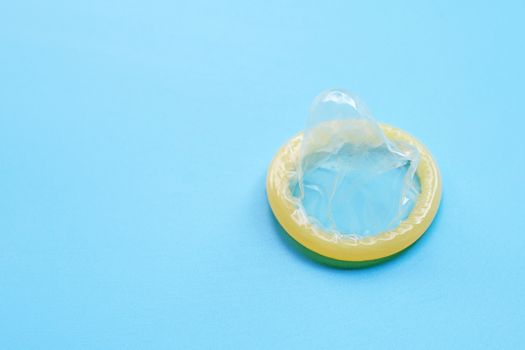 Condom on blue background with copy space. Save sex concept