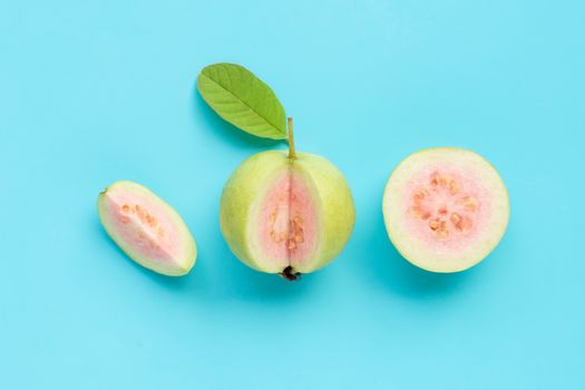 Top view of fresh ripe guava with leaf on blue background. 