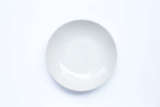 Empty white ceramic plate on white background. Copy space